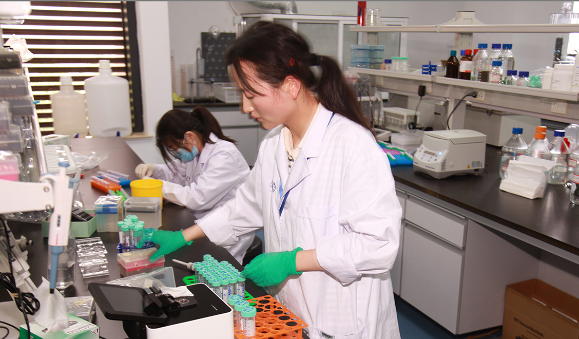 Two female scientists working at lab bench